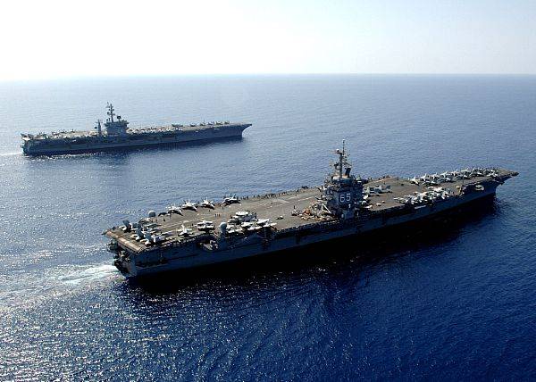 The nuclear-powered aircraft carrier USS Dwight D. Eisenhower (CVN 69), background, sails alongside the nuclear-powered aircraft carrier USS Enterprise (CVN 65) after arriving in the Red Sea.